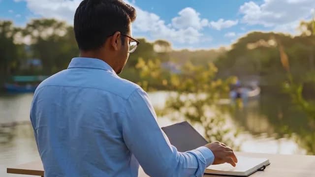 Young Man Reading a Book Outdoors by a Scenic Lake