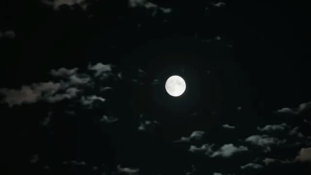 Bright Full Moon Glowing Through Clouds in Dark Night Sky