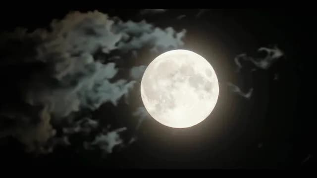 Bright Full Moon Glowing in a Dark Night Sky with Clouds