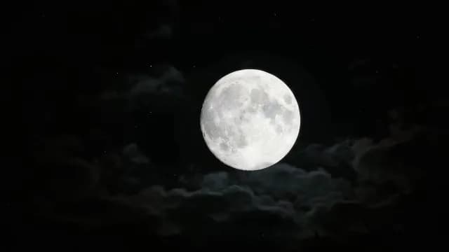 Glowing Full Moon Against a Dark Cloudy Night Sky