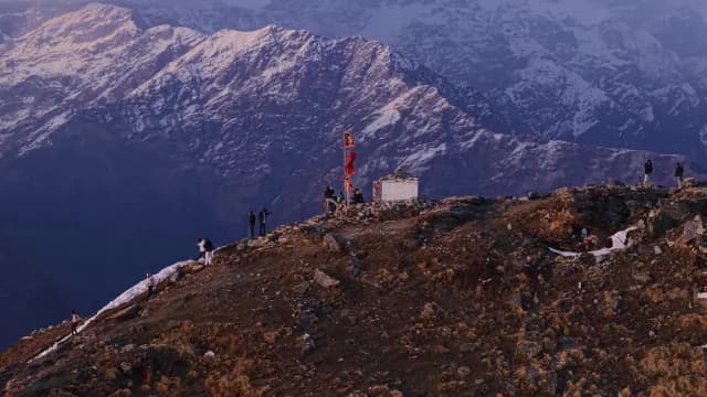 Hikers at a High Altitude Chandrashila Peak and Himalayan Mountains in Chopta, Uttarakhand Mountain Shrine with Snow-Capped Peaks Background
