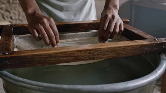 Artisan Hands Crafting Handmade Paper Using Traditional Wooden Frame and Water