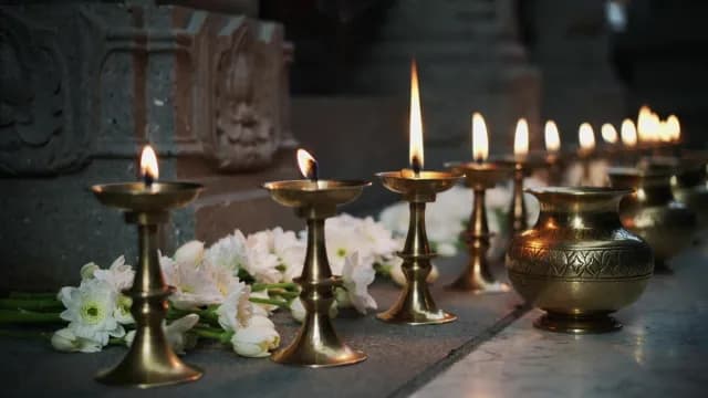Traditional Brass Oil Lamps and White Flowers in a Hindu Temple