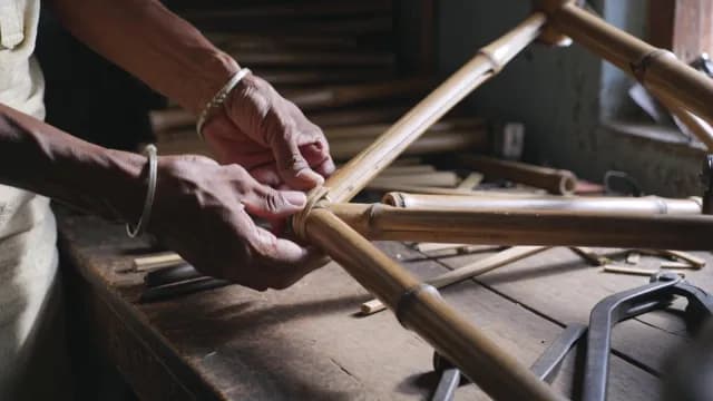 Artisan Crafting Sustainable Bamboo Bicycle Frame in Workshop