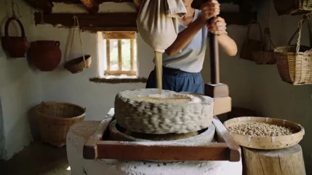 Traditional Stone Mill Grinding Grain into Flour in Rustic Kitchen