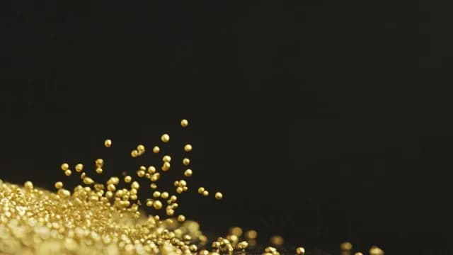 Macro Shot of Golden Grains Bouncing Against Black Background
