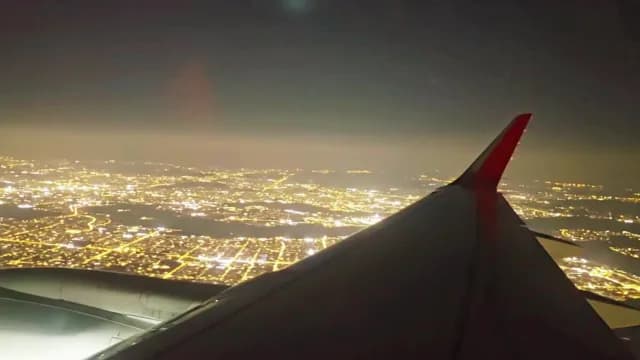 Night Aerial View of City Lights from Airplane Window
