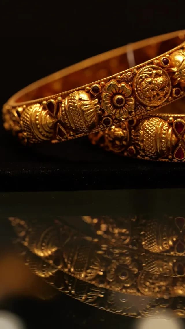 Ornate Traditional Indian Gold Bangles with Intricate Carvings and Rubies