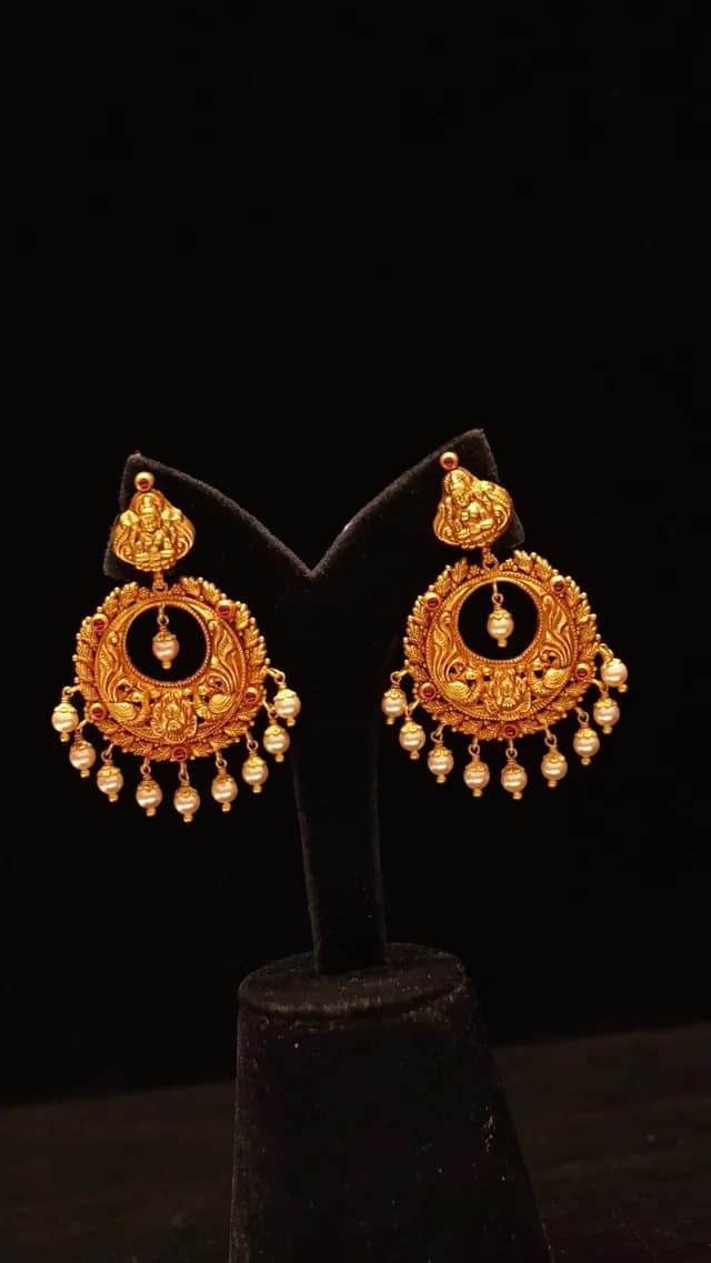 Ornate Traditional Indian Gold Earrings with Pearls on Black Background