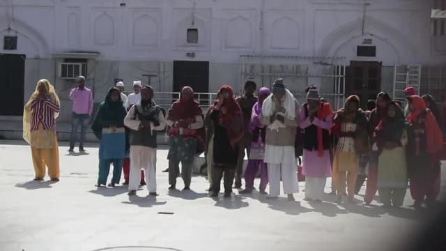 Devotees Praying in the Courtyard of a Historic White Mosque