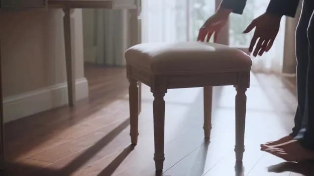 Person Adjusting Elegant Upholstered Stool in Bright Sunlit Room