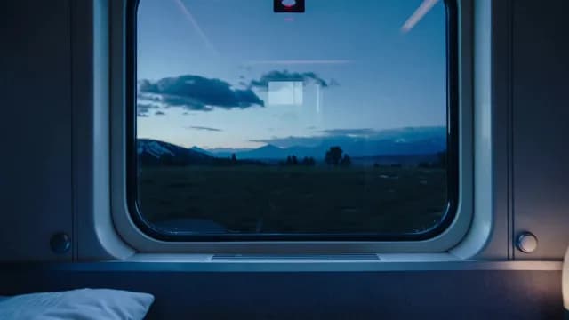 Scenic Mountain Landscape View from a Moving Train Window at Twilight