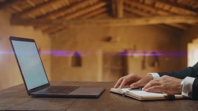 Businessman Working on Laptop and Notebook in Rustic Office Setting