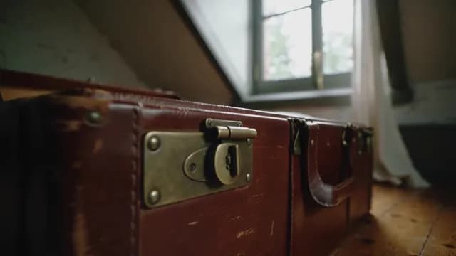 Vintage Brown Leather Suitcase with Brass Latches in Attic Room