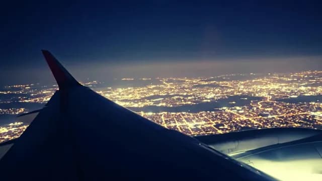 Aerial View of Glowing City Lights from Airplane at Night