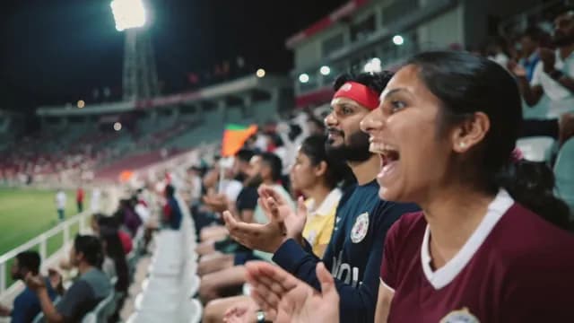 Enthusiastic Fans Cheering and Clapping at a Night Sports Stadium Event