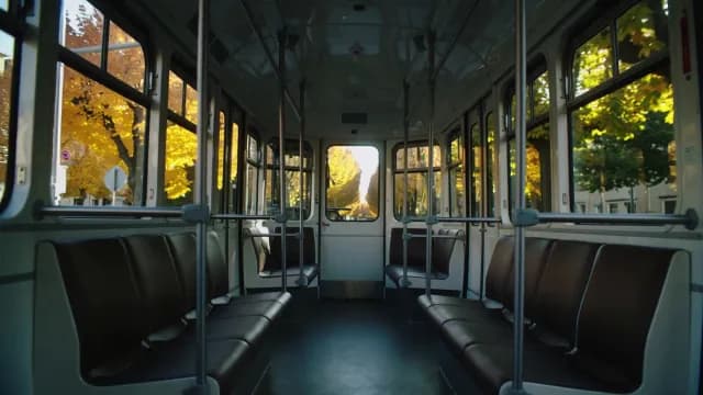 Empty Vintage Tram Interior with Golden Autumn Foliage Outside