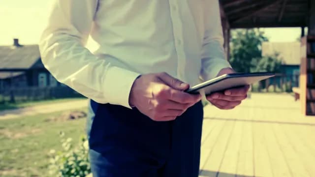 Professional Man Working on Digital Tablet on a Sunny Porch