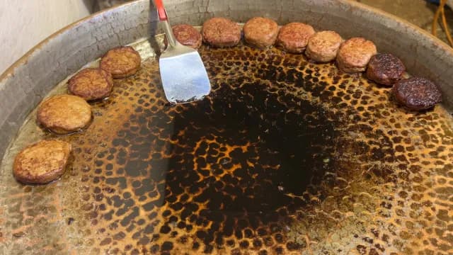 Traditional Meat Patties Frying in a Large Hammered Metal Pan