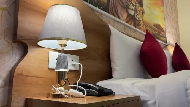 Elegant Hotel Room Bedside Table with Stylish Lamp and Pillows